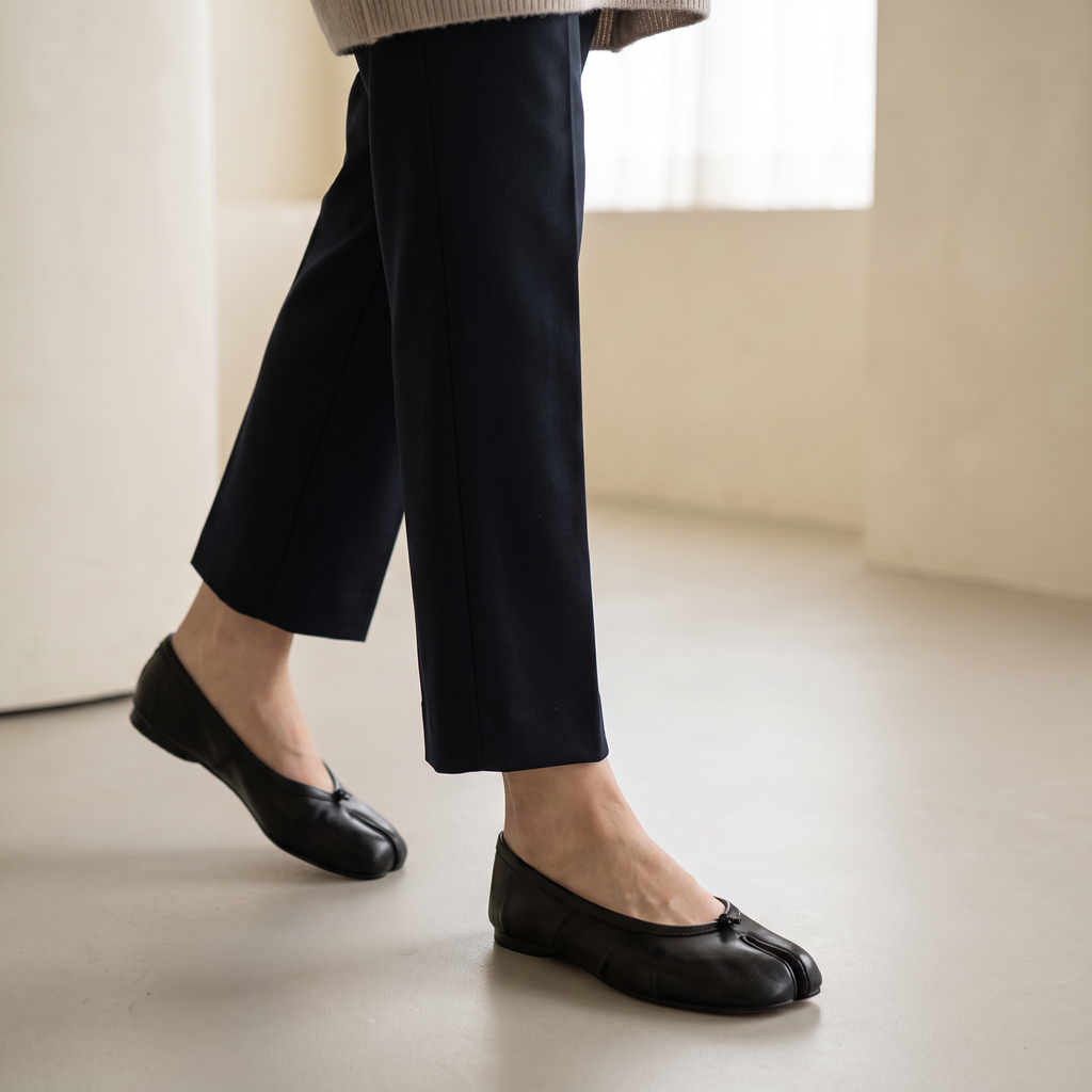Ballerine Tabi nere indossate con pantaloni sartoriali