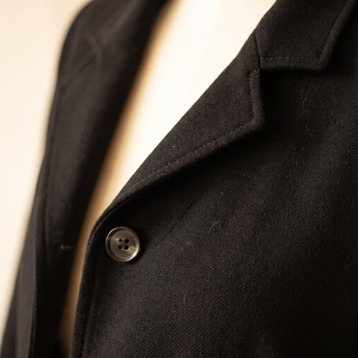 Dettaglio del revers e del bottone del blazer donna nero