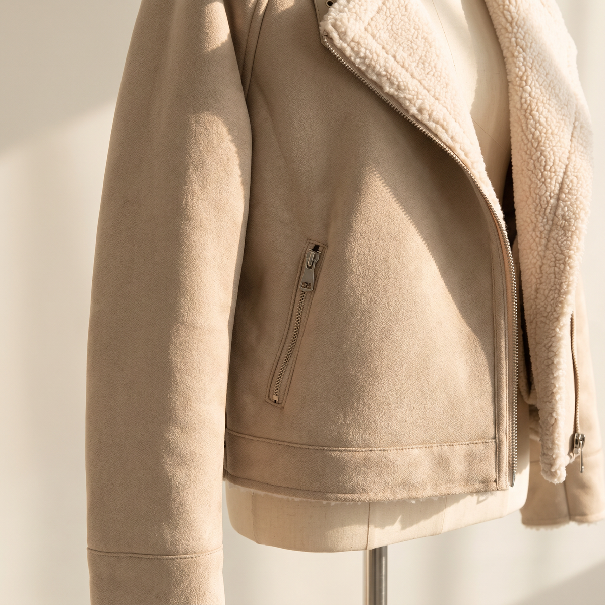 Dettaglio della tasca laterale e della superficie effetto scamosciato del cappotto beige