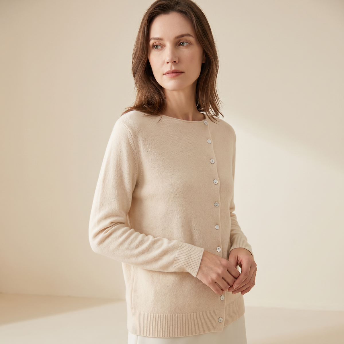 Cardigan donna crema in maglia fine visto di tre quarti con bottoni frontali