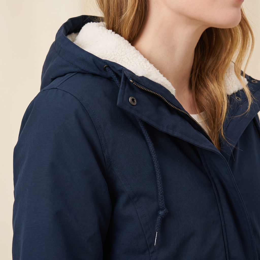 Dettaglio della fodera in pile, del cappuccio regolabile e della zip frontale, giacca blu navy