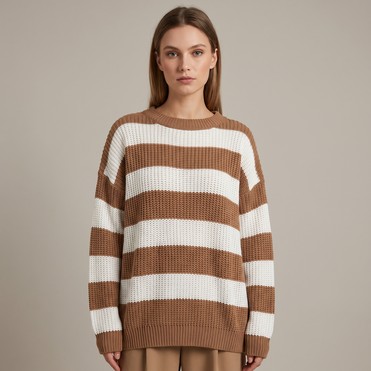 Donna che indossa un maglione oversize a righe caffè e bianco