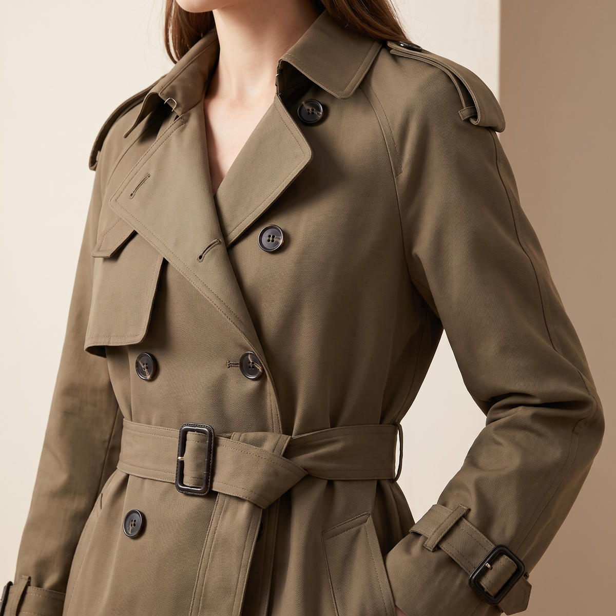 Trench donna doppiopetto di lunghezza media, colore khaki, dettaglio della chiusura doppiopetto e del collo